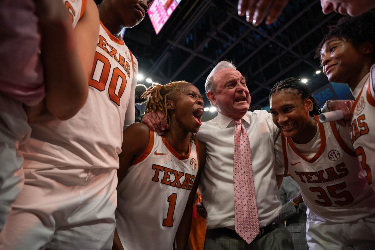Head coach ‎Vic Schaefer smiles in the huddle with players Bryanna Preston (left) and Madison Booker (right) after Texas' win against LSU on Feb. 16, 2025. 