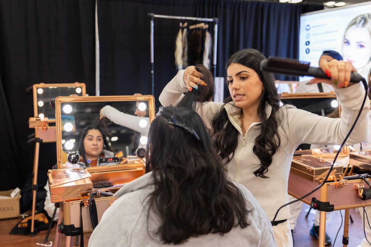An attendee gets her hair curled with DNAHAIRTOOLS at the SXSW Expo on March 9, 2025. 