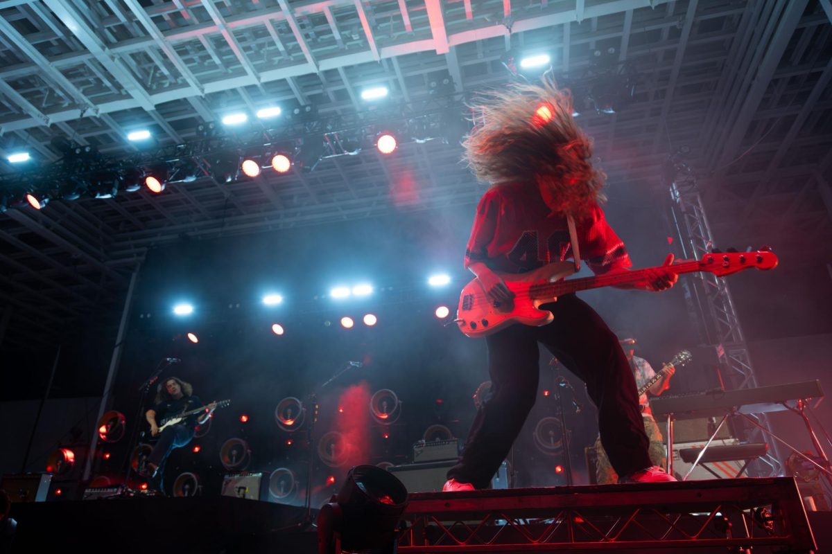 Peach Pit's bass guitarist Peter Wilton headbangs on stage as the band performs at the Moody Amphitheater on June 16, 2025.