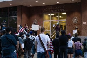 A protester speaks to the crowd in front of the J.J. Jake Pickle Federal Building on June 9, 2025. 